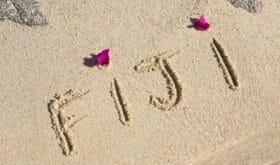 fiji written on a wet beach