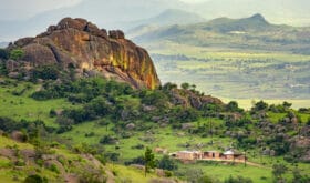Ezulwini valley in Swaziland eSwatini with beautiful mountains, trees and rocks in scenic green valley between Mbabane and Manzini cities. Traditional huts houses of Swaziland